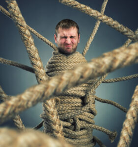 Man stuck in a series of rope symbolizing stuck in behavior